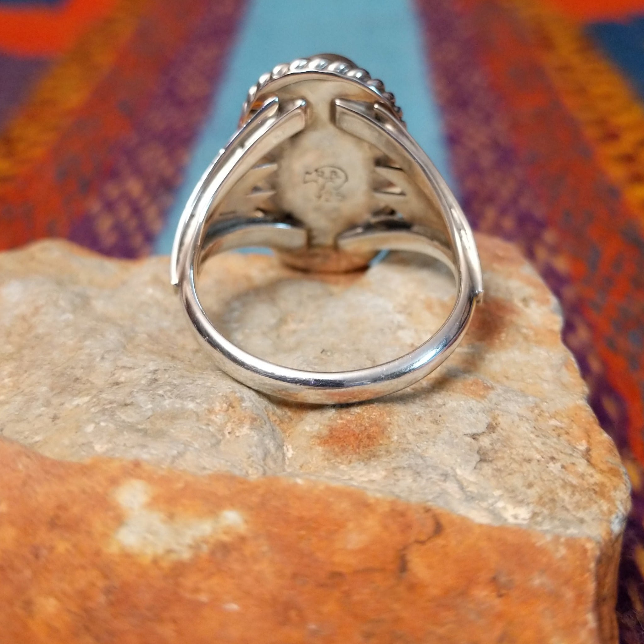 Navajo Turquoise Ring featuring a large elongated oval turquoise stone with natural brown and dark matrix, framed by twisted rope detailing and set in Sterling Silver with a split-shank band; underside view.