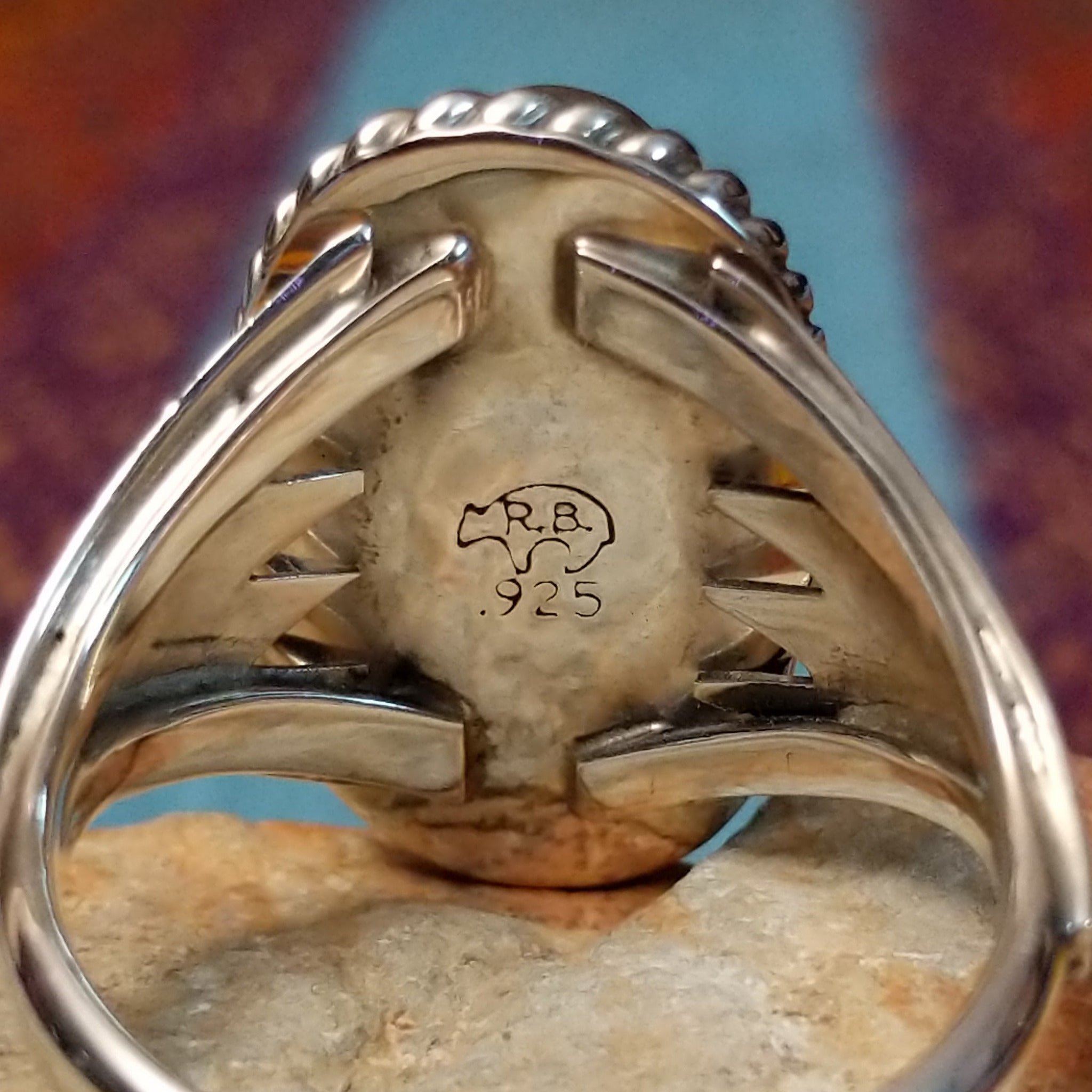 Navajo Turquoise Ring featuring a large elongated oval turquoise stone with natural brown and dark matrix, framed by twisted rope detailing and set in Sterling Silver with a split-shank band; artisan and .925 (Sterling Silver) stamp.