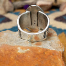 Handcrafted Navajo sterling silver ring by L.P. featuring a large oval natural turquoise cabochon with subtle golden matrix, set in a twisted rope bezel on a wide hand-stamped split-shank band; underside view.