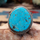 Sterling silver ring with oval turquoise set in a twisted rope bezel.