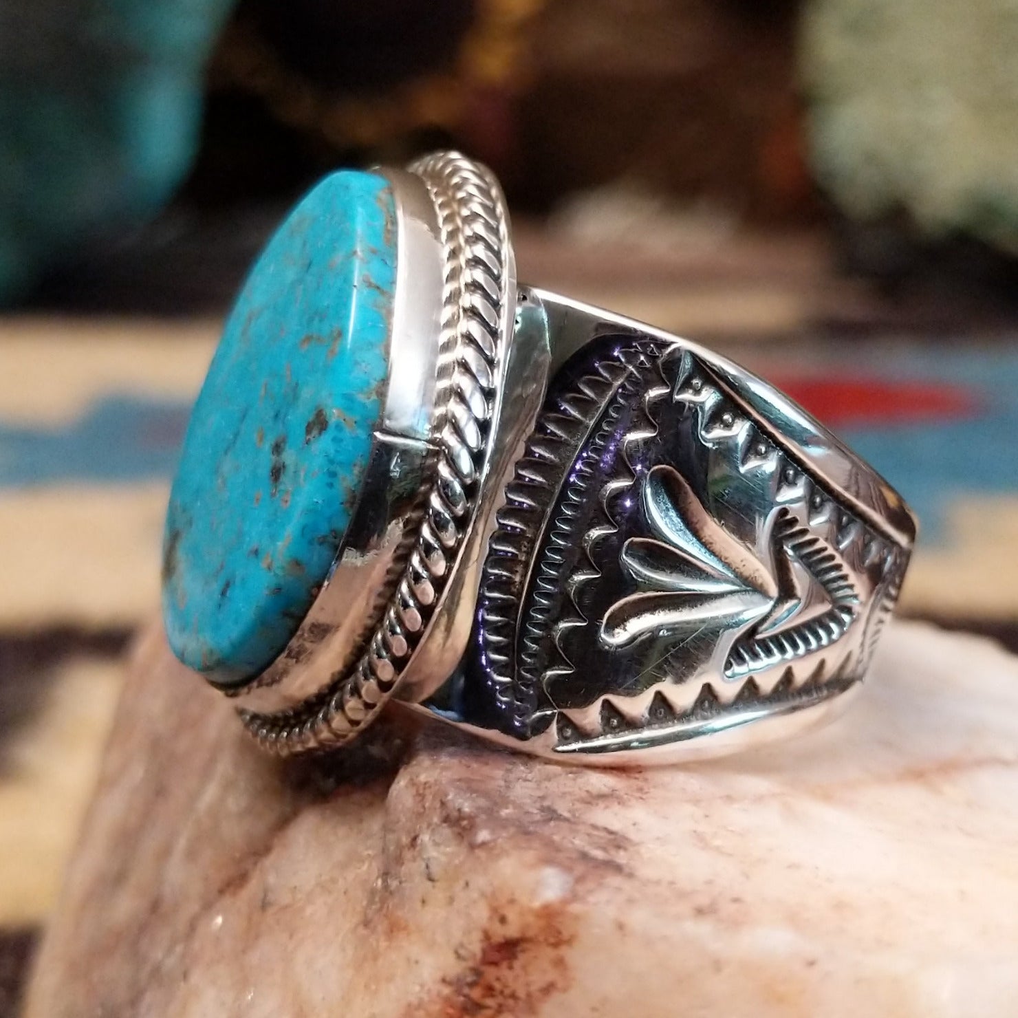 Sterling silver ring with oval turquoise set in a twisted rope bezel.