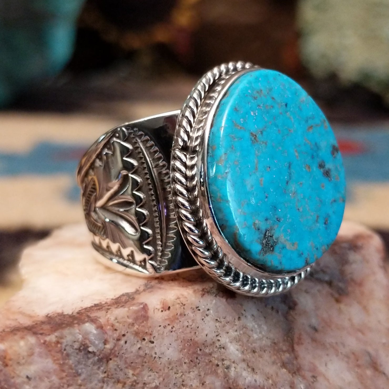 Sterling silver ring with oval turquoise set in a twisted rope bezel.