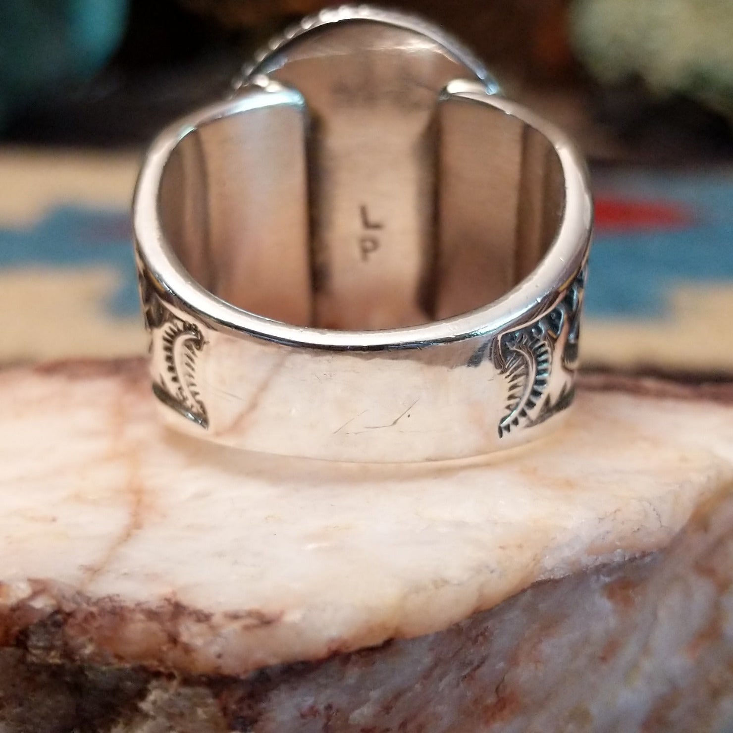 Sterling silver ring with oval turquoise set in a twisted rope bezel.