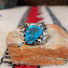 Navajo turquoise ring by S. with silver drops and tapered band.