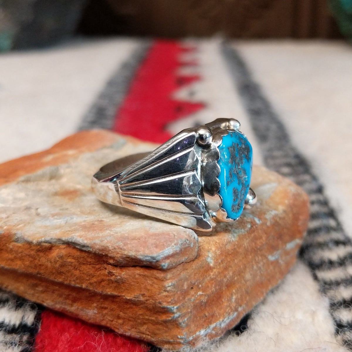 Navajo turquoise ring by S. with silver drops and tapered band.