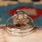 Navajo turquoise ring by S.S., featuring a vibrant blue turquoise stone with natural black matrix, surrounded by a twisted rope border and set in a handcrafted sterling silver split shank band.  Artisan and Sterling Silver stamp.