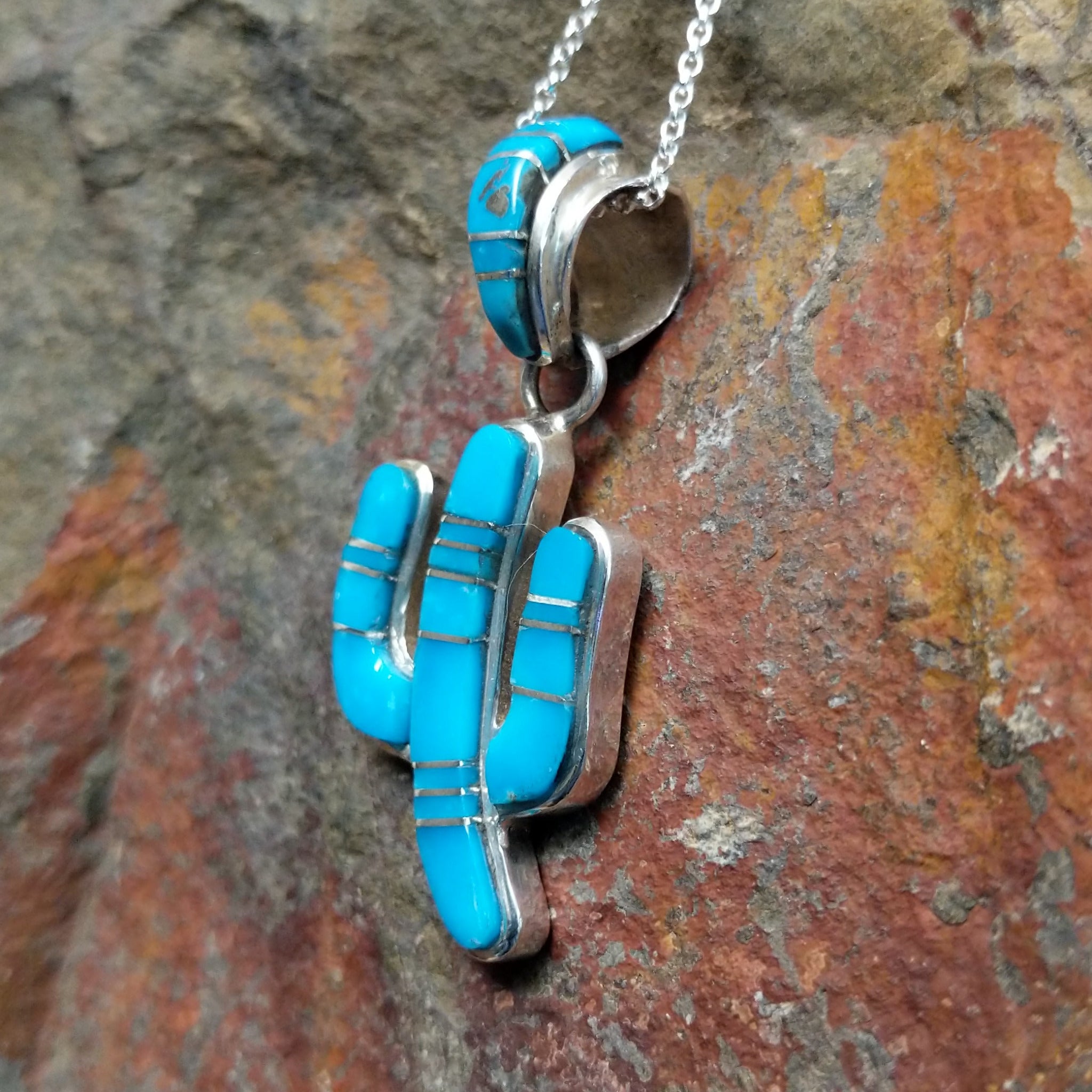 Handcrafted sterling silver turquoise inlay saguaro cactus pendant by B.J., featuring an inlay bale and traditional Navajo design; side view.