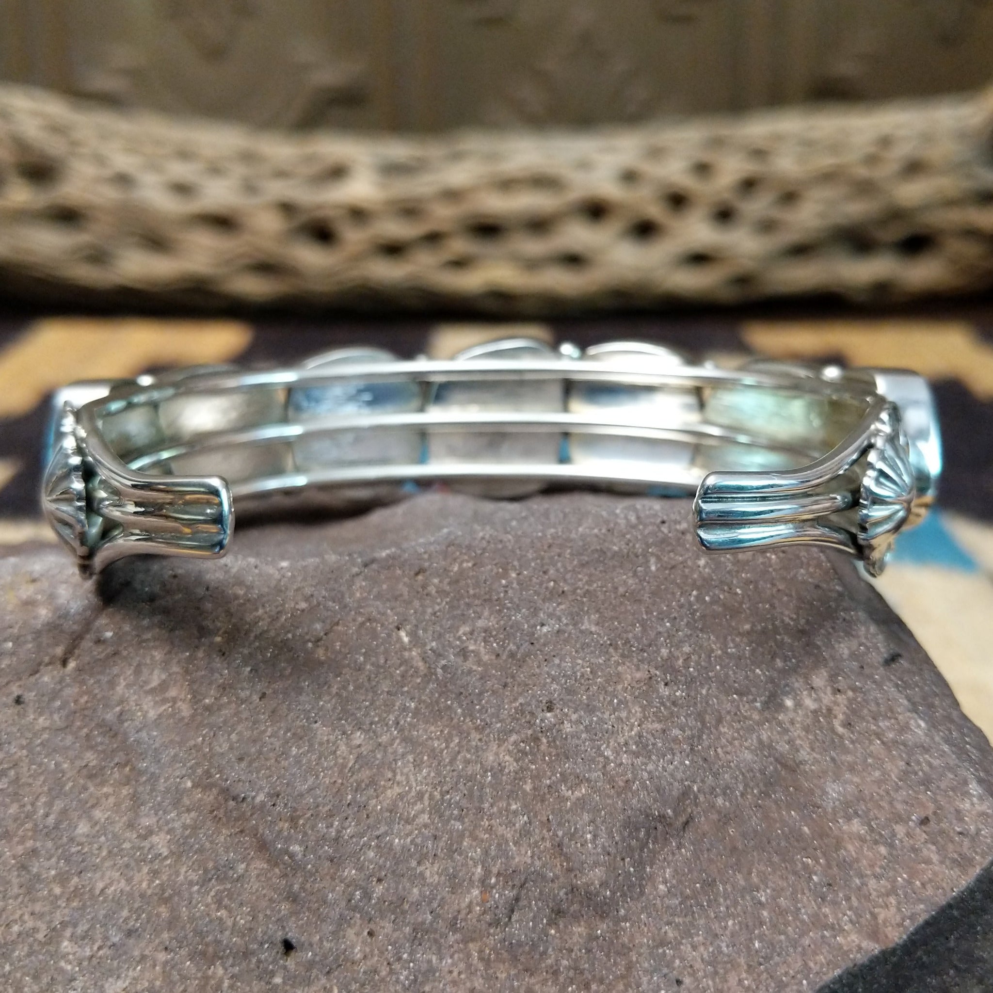 Navajo turquoise septet cuff, featuring seven blue turquoise stones with natural matrix set in a handcrafted sterling silver cuff; underside view.