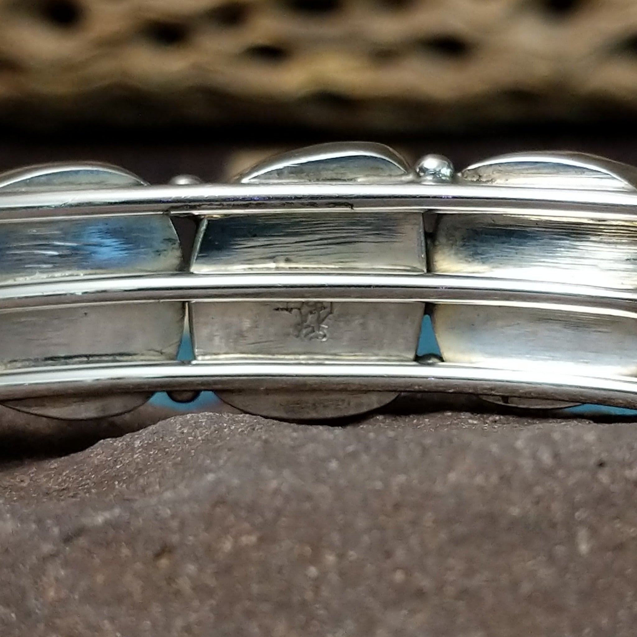 Navajo turquoise septet cuff, featuring seven blue turquoise stones with natural matrix set in a handcrafted sterling silver cuff; artisan and Sterling Silver stamp.