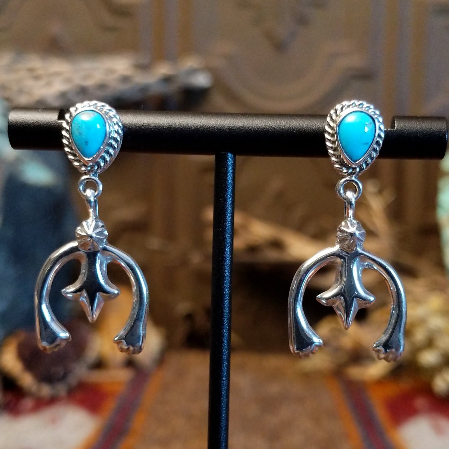 Turquoise set in bezels framed by twisted rope with the suspended naja design.