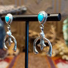 Turquoise set in bezels framed by twisted rope with the suspended naja design.