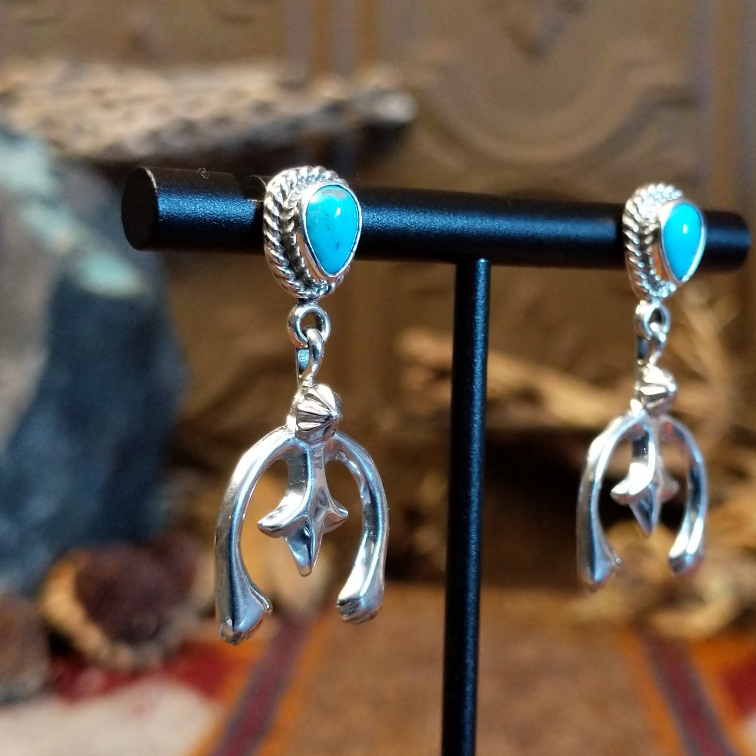 Turquoise set in bezels framed by twisted rope with the suspended naja design.