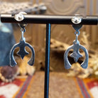 Turquoise set in bezels framed by twisted rope with the suspended naja design.
