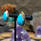 Navajo 14k gold teardrop earrings with turquoise stone and fan accents.