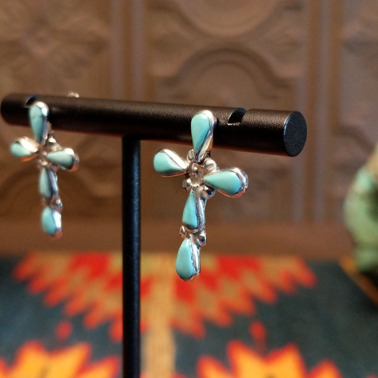 Sterling silver cross earrings with turquoise set in teardrop-shaped bezels.
