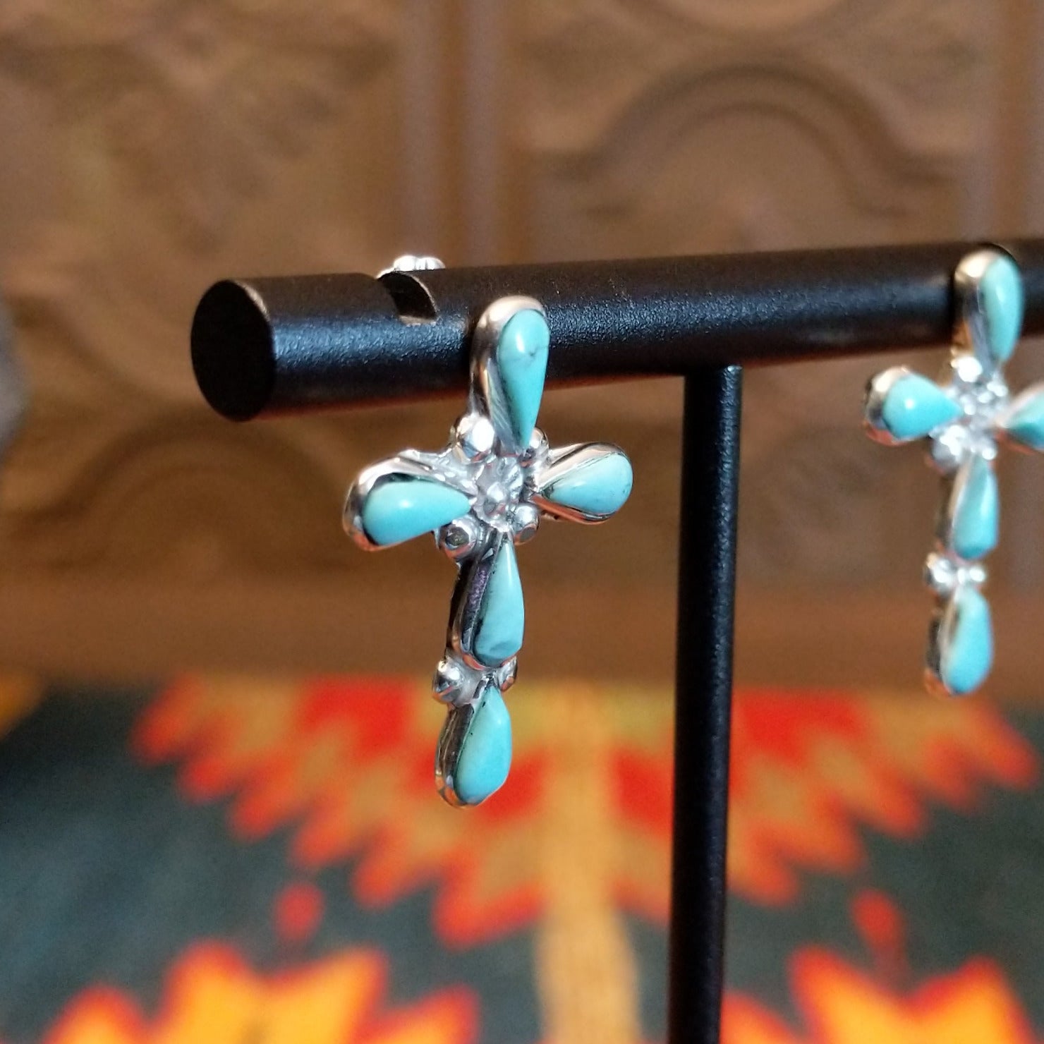 Sterling silver cross earrings with turquoise set in teardrop-shaped bezels.