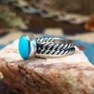 Sterling silver ring with turquoise set in the oval bezel and twisted silver band.