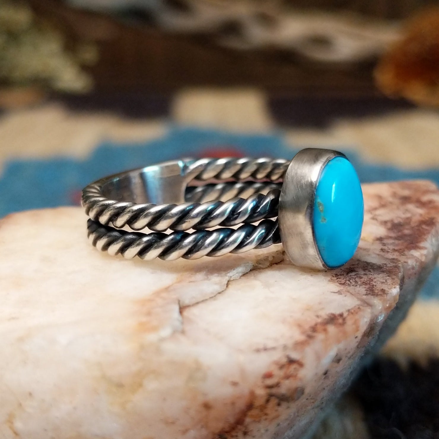 Sterling silver ring with turquoise set in the oval bezel and twisted silver band.