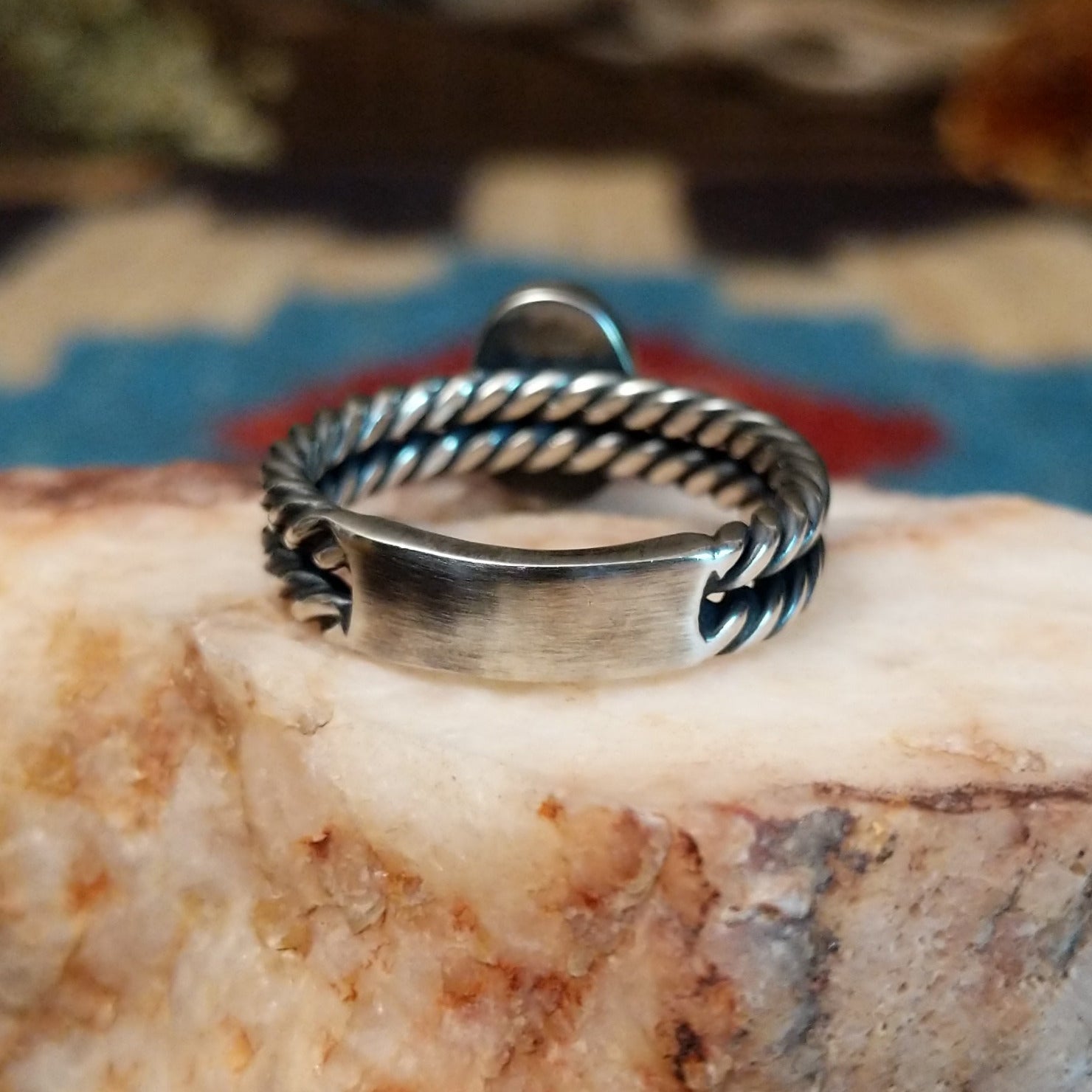 Sterling silver ring with turquoise set in the oval bezel and twisted silver band.