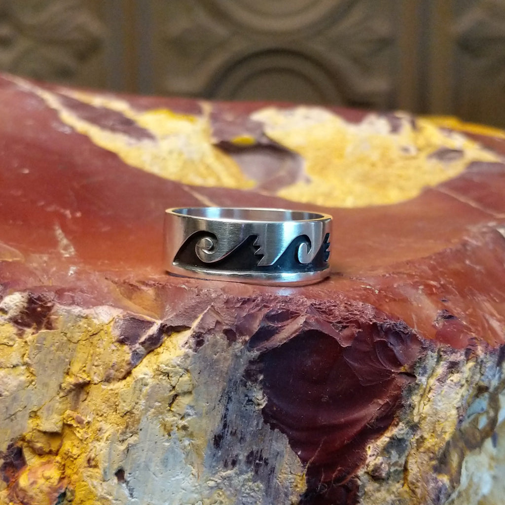 Sterling silver ring with water waves and rain clouds along the surface.