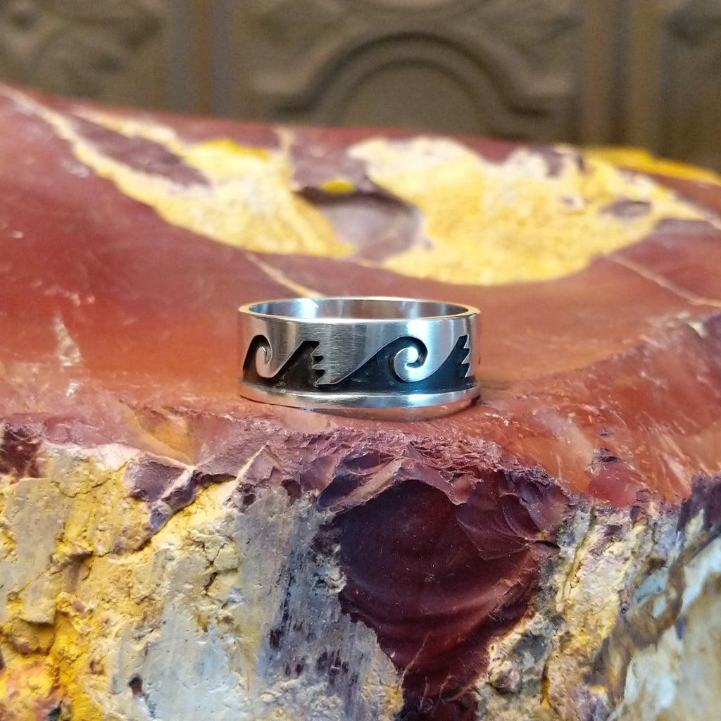Sterling silver ring with water waves and rain clouds along the surface.