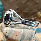 Sterling silver cuff bracelet with a white buffalo stone set in a round bezel, framed by incised lining and a layered band.
