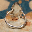 Handcrafted Navajo sterling silver ring featuring an elongated oval White Buffalo inlay with black onyx, turquoise, and sterling silver geometric accents in a polished bezel setting; Sterling Silver stamp.