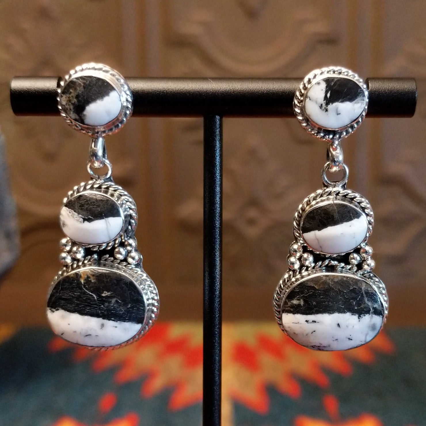 Sterling silver dangle earrings with white buffalo set in the bezels, framed by twisted rope and dotted accents.