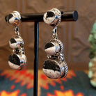 Sterling silver dangle earrings with white buffalo set in the bezels, framed by twisted rope and dotted accents.