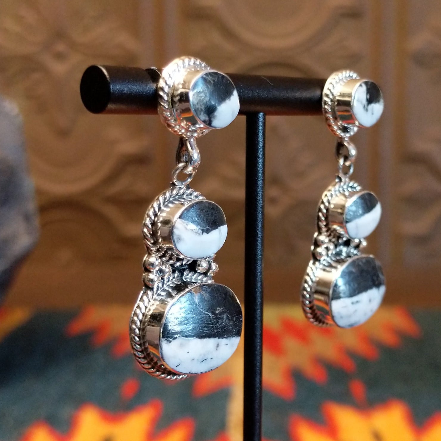 Sterling silver dangle earrings with white buffalo set in the bezels, framed by twisted rope and dotted accents.