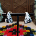 Navajo White Buffalo Triangle Earrings by L.P. featuring polished triangular white stones with natural black matrix patterns set in smooth silver bezels.
