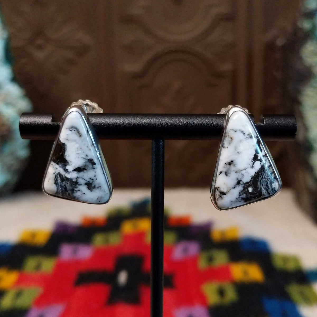 Navajo White Buffalo Triangle Earrings by L.P. featuring polished triangular white stones with natural black matrix patterns set in smooth silver bezels.