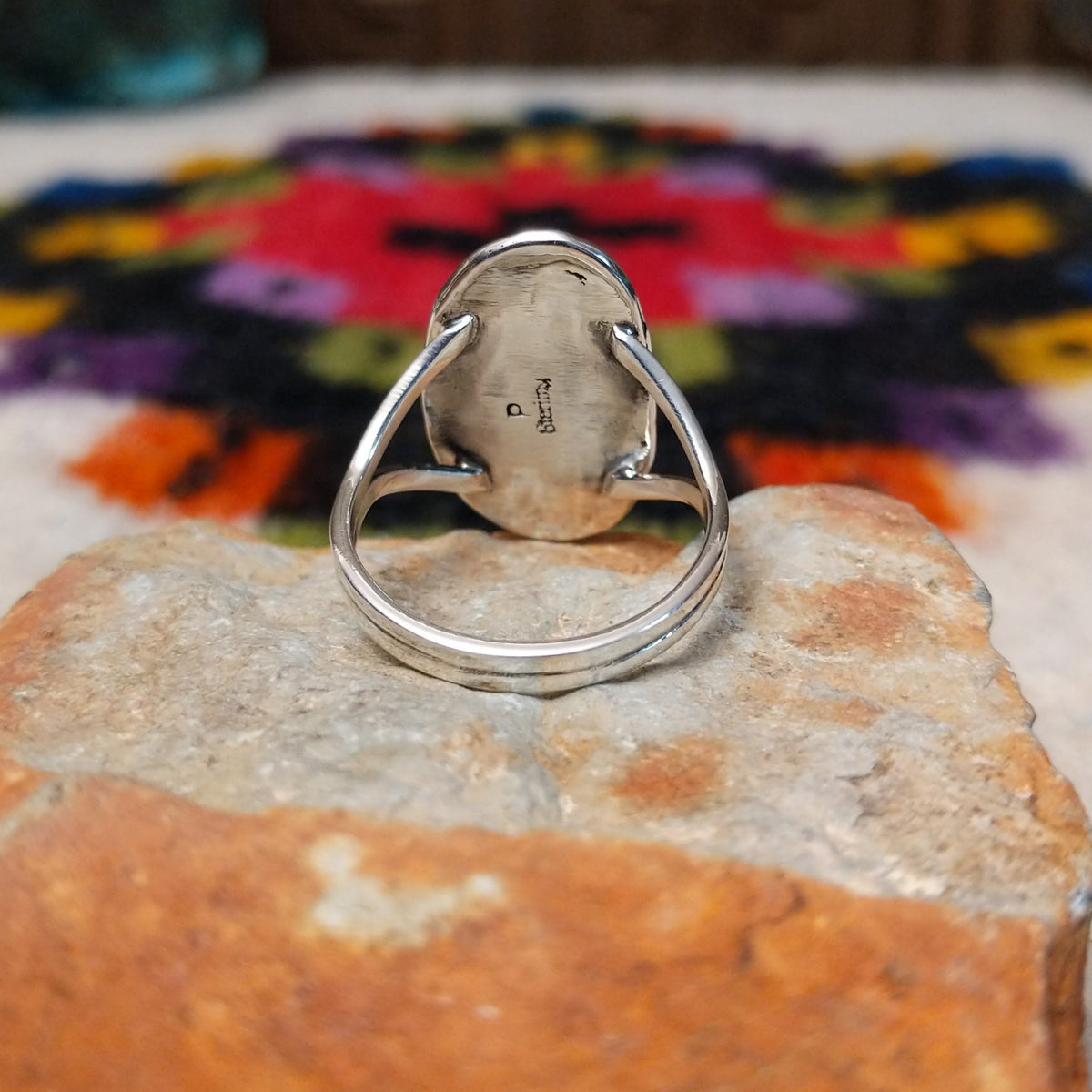 Navajo Wild Horse Ring by P. with elongated stone and stamped setting.