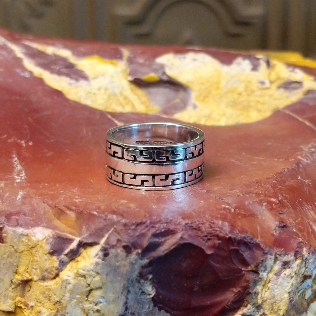 Sterling silver ring with patterned designs on the band.
