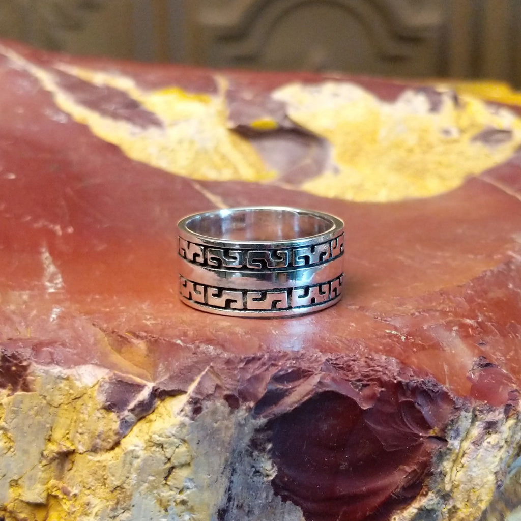 Sterling silver ring with patterned designs on the band.