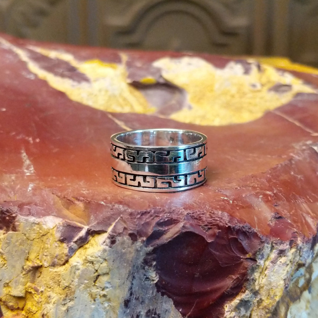 Sterling silver ring with patterned designs on the band.