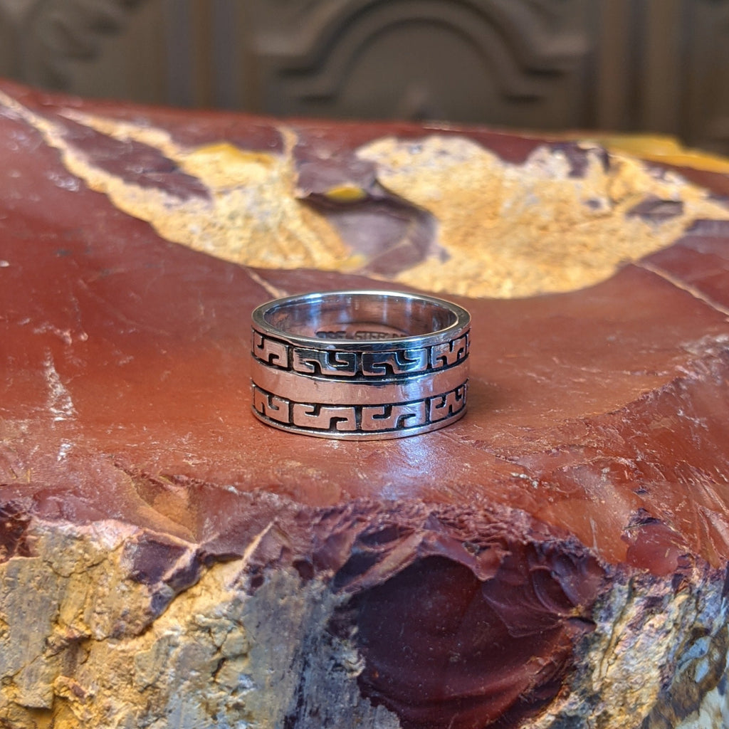 Sterling silver ring with patterned designs on the band.
