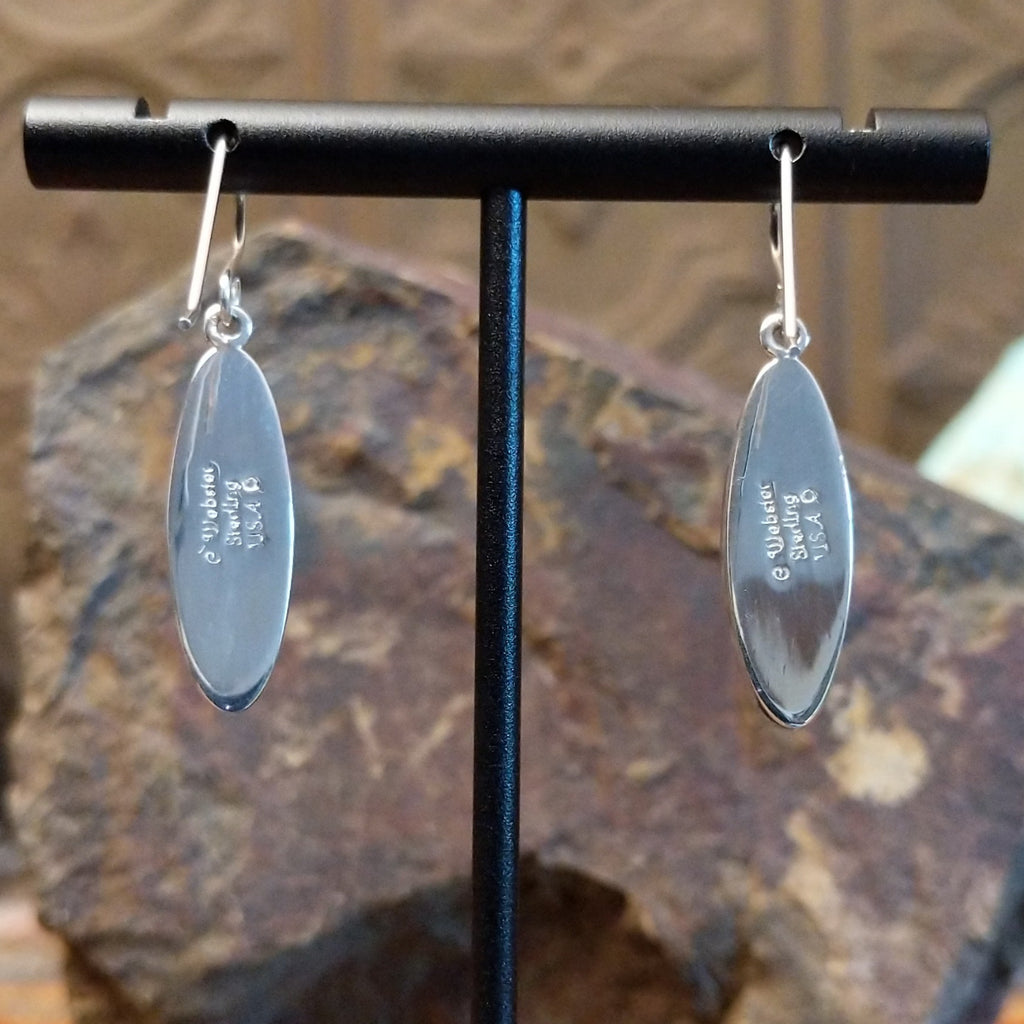 The backs of the earrings feature the artisan's stamped signature.