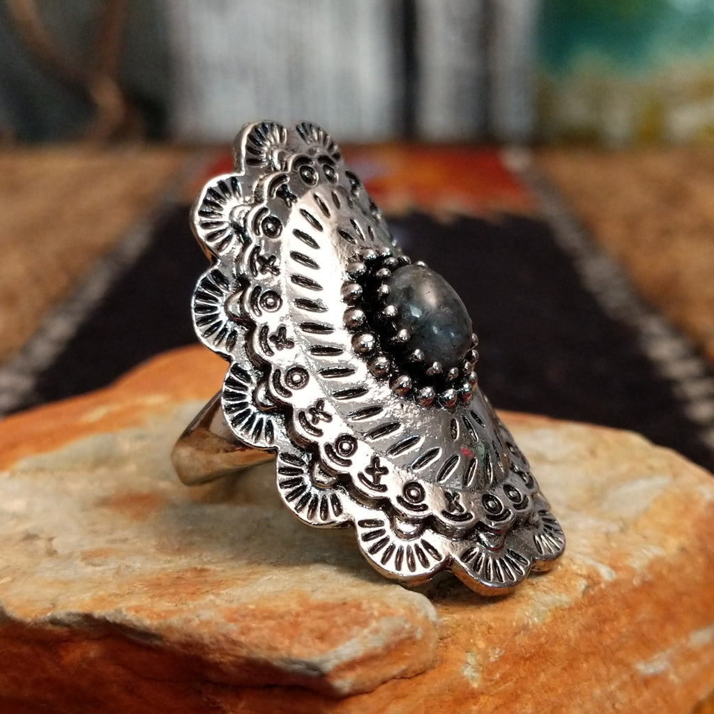 A nickel-free metal ring with a dark stone center, framed by dotted and patterned edges.