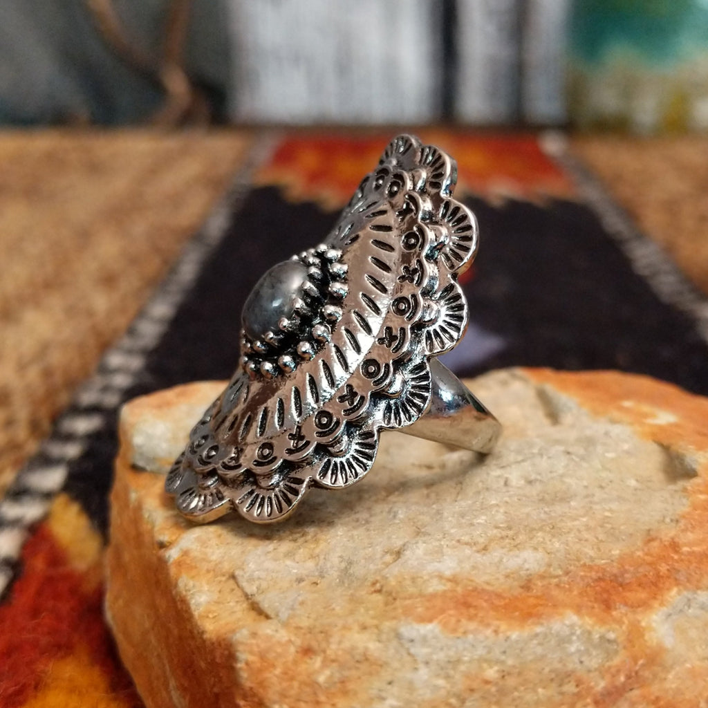 A nickel-free metal ring with a dark stone center, framed by dotted and patterned edges.