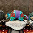 Armadillo figurine in bright teal with orange flowers, featuring greenery and dot work accents.