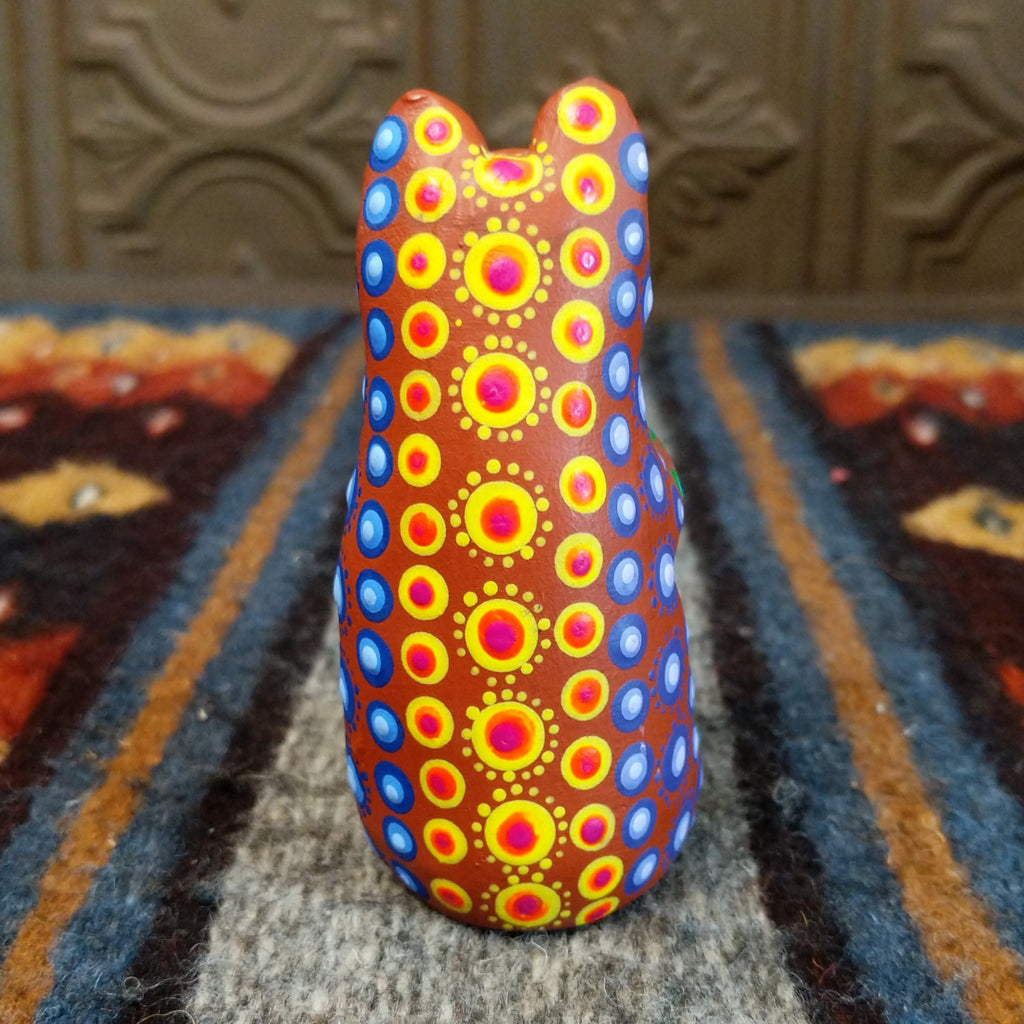 Oaxacan bear wood carving painted in rich brown, adorned with vibrant multicolor patterns.