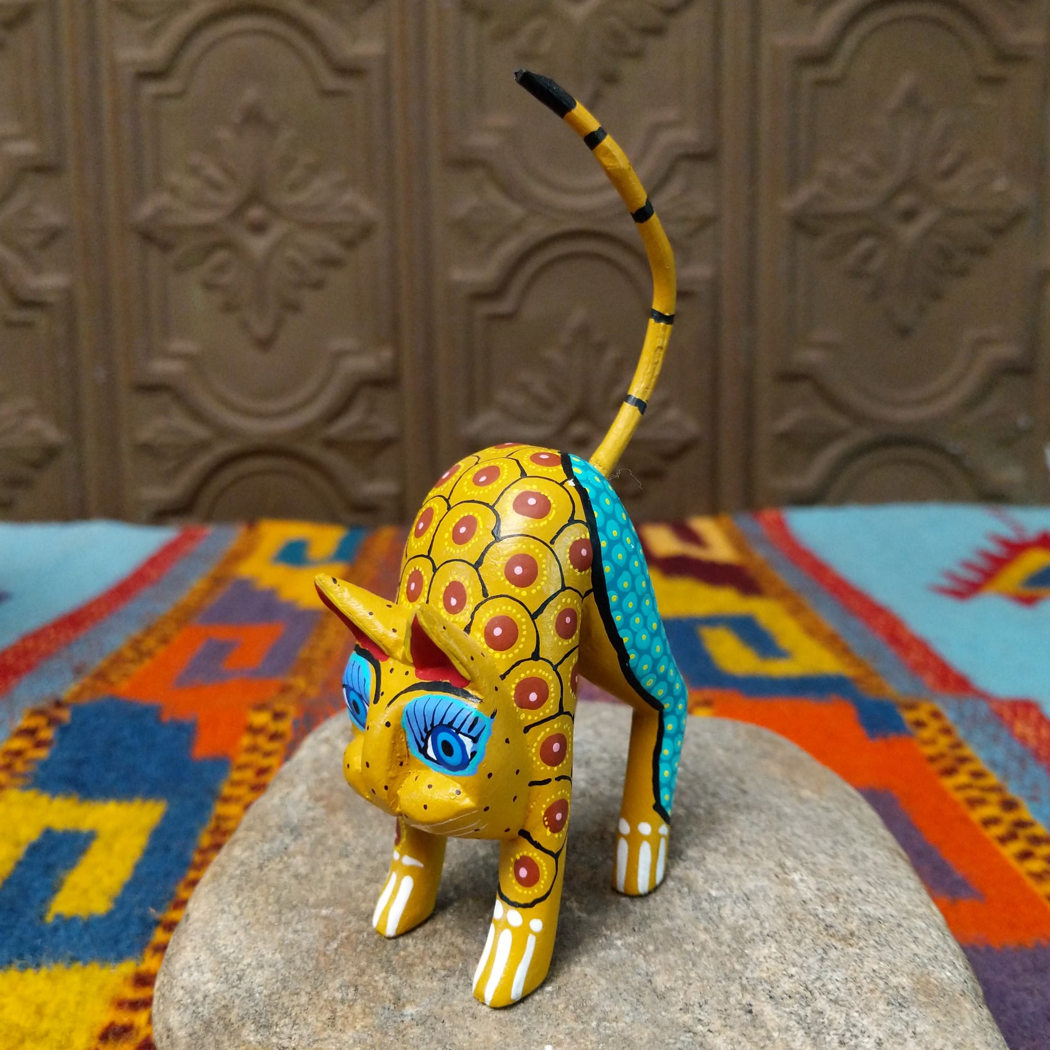 Oaxacan cat wood carving with a tall upright body, detachable parts, and colorful hand-painted geometric patterns.