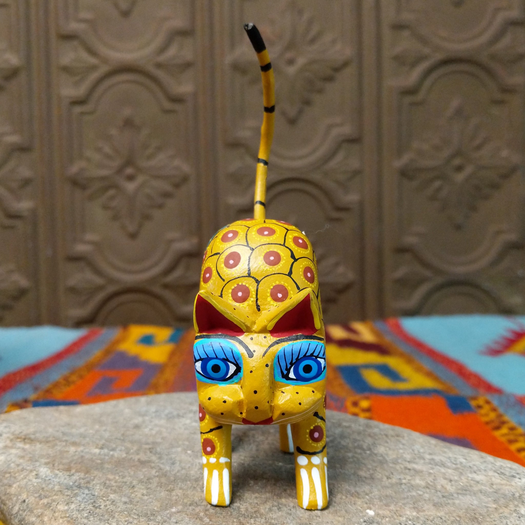 Oaxacan cat wood carving with a tall upright body, detachable parts, and colorful hand-painted geometric patterns.