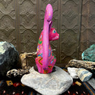 Smooth wood painted in pink, showcasing swirling with multicolor motifs.