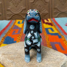 Oaxacan dog wood carving by Jose Olivera Perez with an open mouth, raised curved tail, and hand-painted floral and leafy designs.