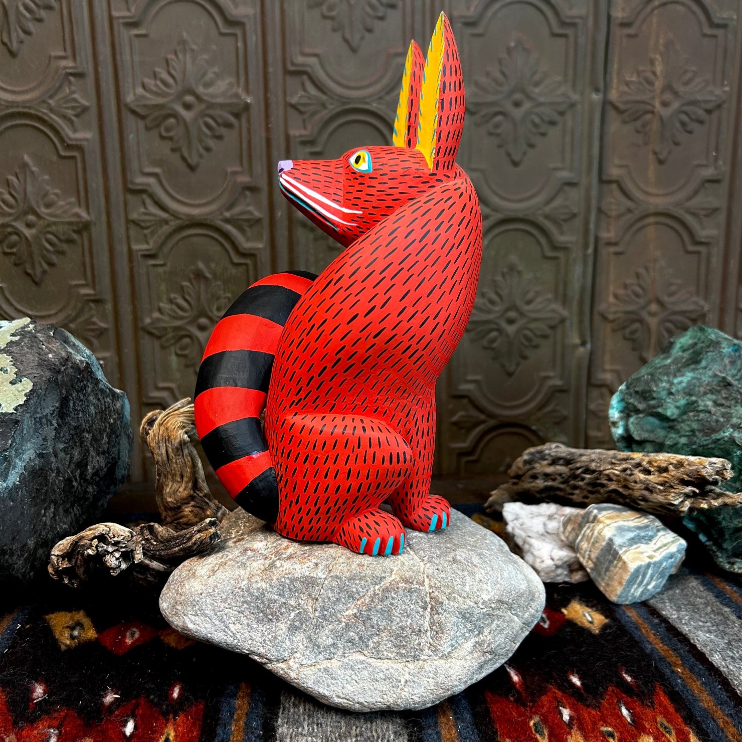 Wood body curves, showcasing a black and red striped tail with fine blue detailing on its paws.