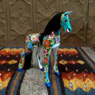Oaxacan horse carving painted in vibrant colors, with black string hair forming a flowing mane.