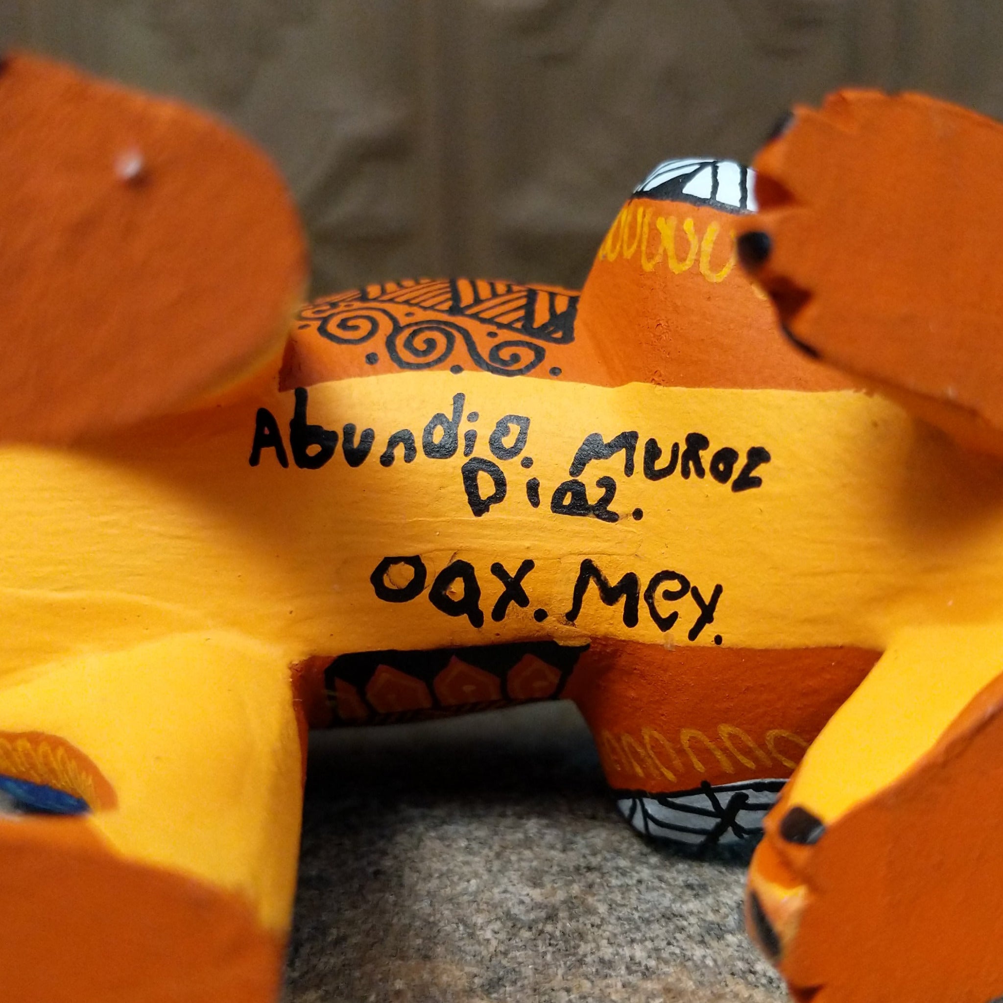 Base of Oaxacan jaguar wood carving signed by artist Abundio Muñoz of Díaz Ordaz, Oaxaca, Mexico.