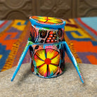 Oaxacan owl wood carving with oversized round eyes and a colorful patchwork of birds, leaves, dots, and abstract painted designs.